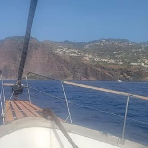 The bow of the sailing boat below the Madeira cliffs