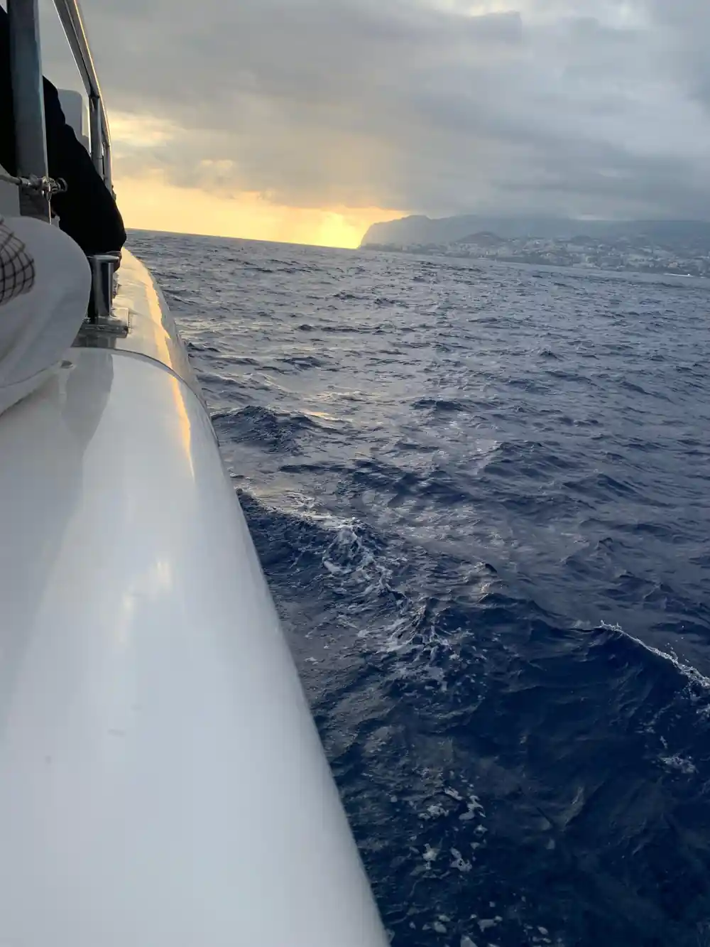 The bow cutting through water at dusk