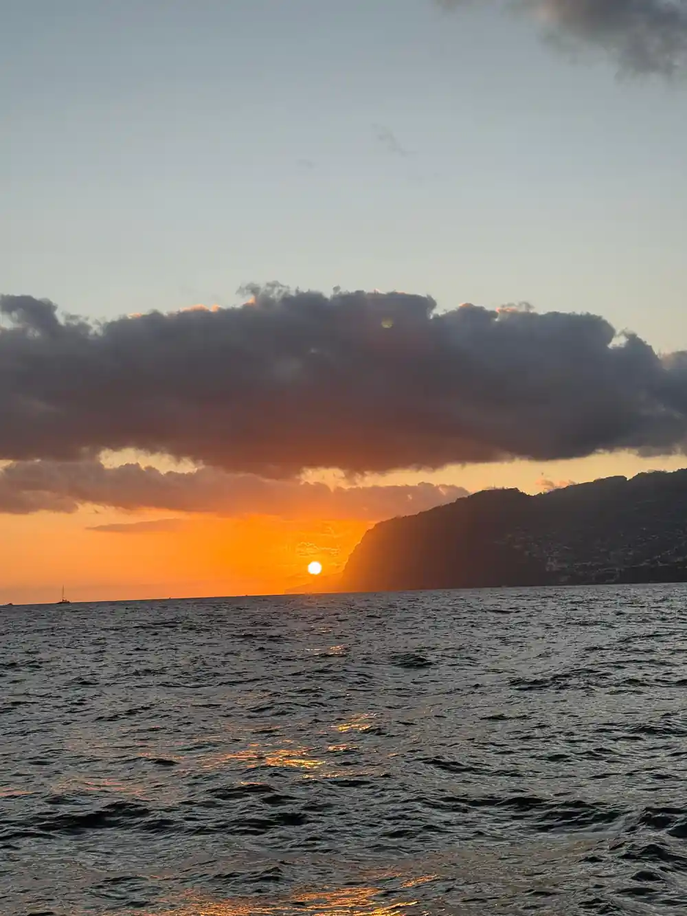 Sunset light over the sea and a dark headland